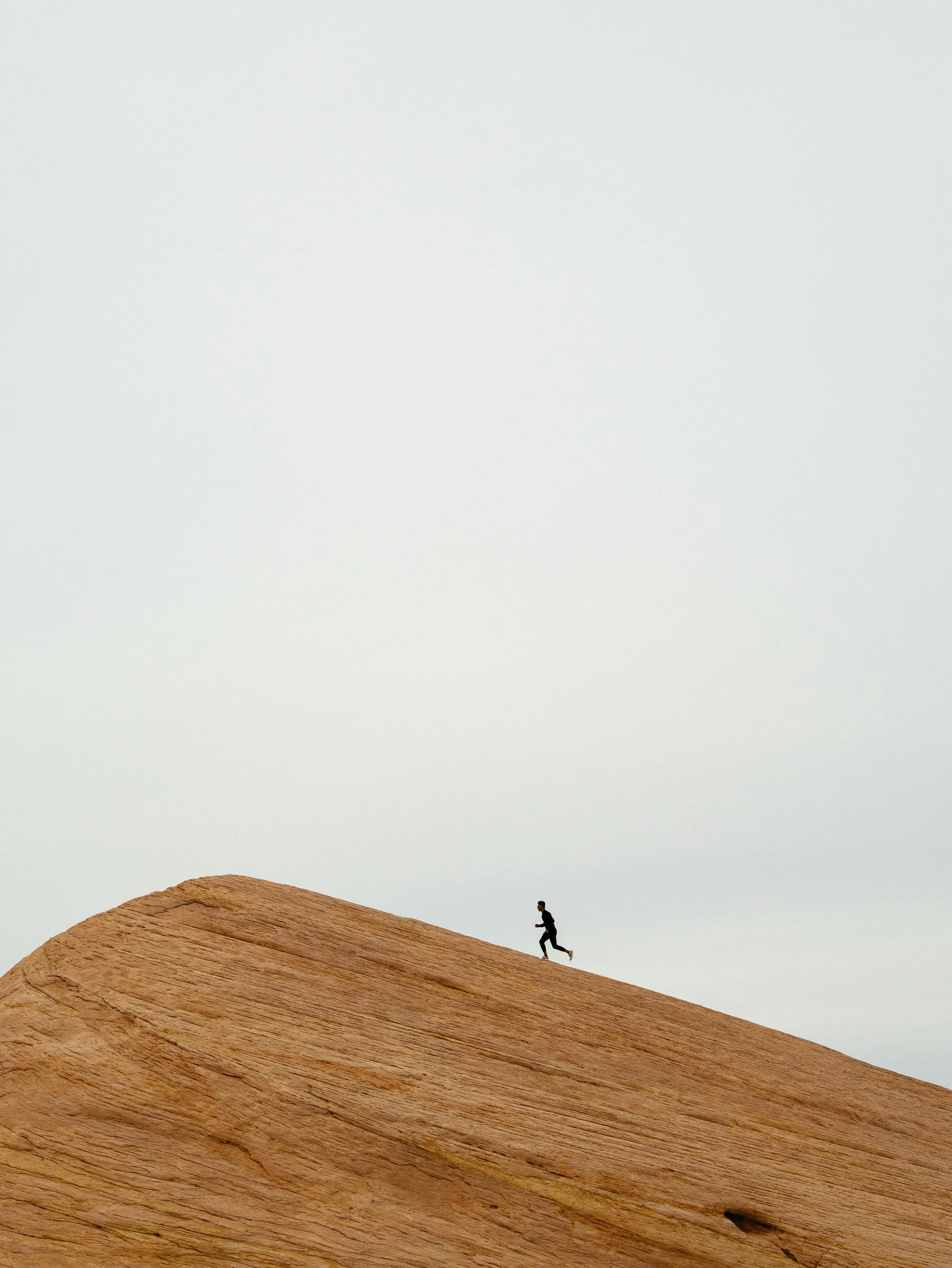 Man running up a sand hill